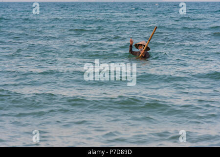 Chasseur, pêcheur de moules coquillages portant un chapeau de paille, la plage Cua Dai à Hoi An, Vietnam Banque D'Images