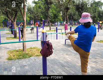 Woman working out sur l'équipement public dans le parc du Temple du Ciel, Beijing Banque D'Images