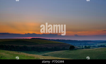 Coucher du soleil sur l'été les South Downs - haute résolution cousue panorama de l'heure d'or lumière sur Butser Hill de l'Est ci-dessus, Meon Hamshire. UK Banque D'Images