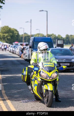 Motocycliste police en uniforme assis sur moto garée en attente, dans une route secondaire, à l'escorte de la princesse Anne's véhicule à travers les rues de Worcester. Banque D'Images