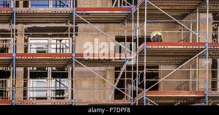 Façade avec échafaudages et un travailleur de travailler sur la rénovation, l'arrière du bâtiment Banque D'Images