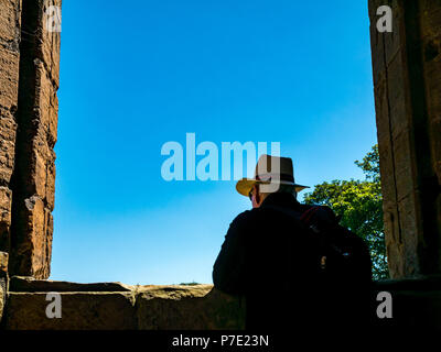 Silhouette encadrée d'un homme portant chapeau Panama dans le cadre de la vitre en ruine avec ciel bleu, le Palais de Linlithgow, West Lothian, Scotland, UK Banque D'Images