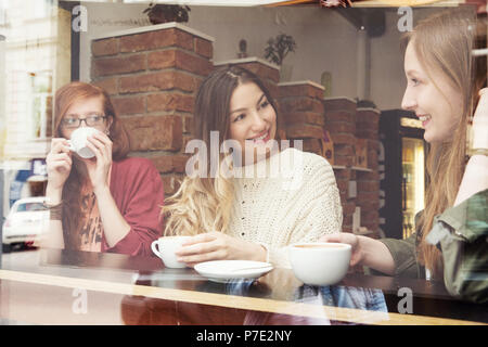 Les jeunes femmes chatting over coffee in cafe Banque D'Images