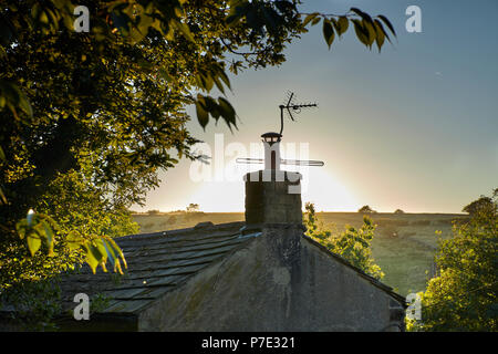 Chalet landes eve avec la poussière et voler les choses en lumière par le soleil en contre-jour. Nidderdale Banque D'Images