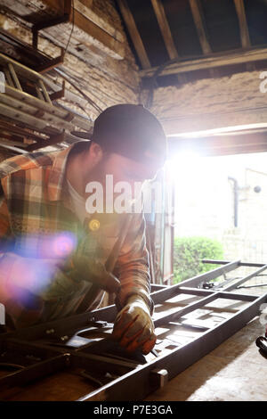 Blacksmith hammering metal sur l'établi dans la région de forgerons shop