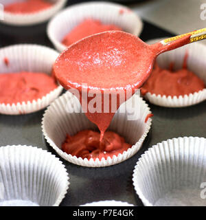 Faire de petits gâteaux. Remplissage par la cuillère avec une pâte à muffins pour Rose Banque D'Images