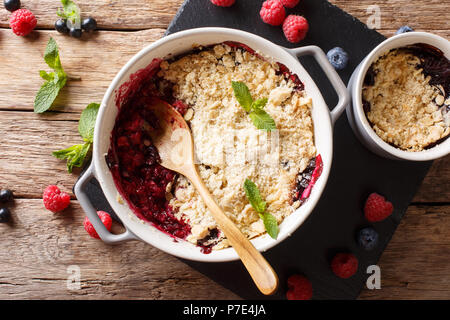 La cuisine anglaise : berry crumble, décoré avec des gros plan de menthe sur la table supérieure horizontale. Vue de dessus Banque D'Images