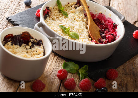 Crumble délicieux mélange de groseilles, framboises et bleuets décoré à la menthe close up sur la table horizontale. Banque D'Images