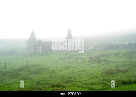 La maison abandonnée crofters dans un épais brouillard, îles Shetland, Écosse, Royaume-Uni Banque D'Images