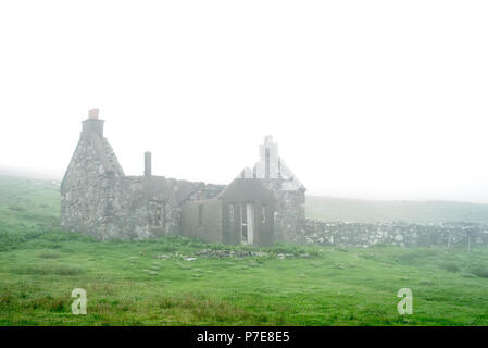 La maison abandonnée crofters dans un épais brouillard, îles Shetland, Écosse, Royaume-Uni Banque D'Images