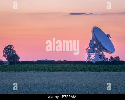 Couleurs pastel sur le ciel en été coucher de soleil sur l'antenne radiotélescope Banque D'Images