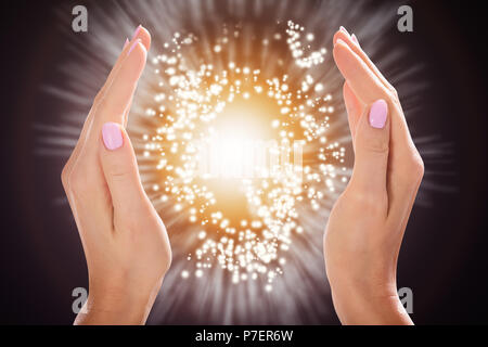 Close-up of a Woman's Hand Holding Light Against Colorful Background Banque D'Images