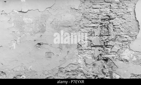 Fond plein cadre d'une altération, endommagés et paroi peinte en noir et blanc. Le plâtre est retiré en partie révéler briques anciennes. Banque D'Images