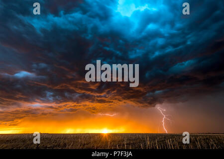 La nuit, un mezocyclone tornadiques orage vis tire d'électricité vers le sol et s'allume le terrain et chemin de terre dans la région de Tornado Alley. Banque D'Images
