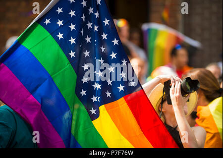 Drapeau américain avec des étoiles et rayures arc-en-ciel de la gay pride d'être agité à l'assemblée annuelle Gay Pride Parade à Greenwich Village, NEW YORK Banque D'Images