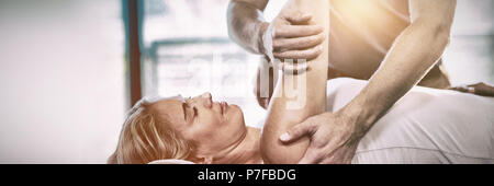 Femme recevant la thérapie de l'épaule de physiothérapeute Banque D'Images