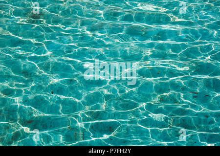 Résumé fond bleu. L'eau sale dans la piscine bleue dans la lumière du soleil. Les reflets sur la surface de l'eau Banque D'Images