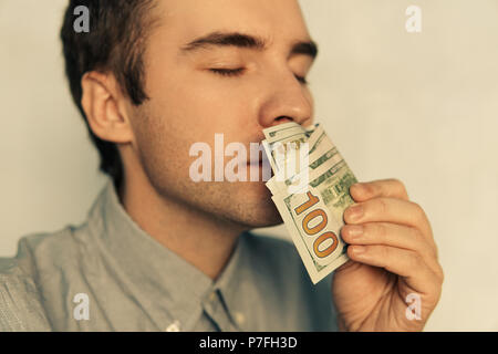 L'inhalation de l'homme de dollars. La douce odeur de l'argent. Jeune mec reniflant 500 dollar gagné de l'argent. Salaire. L'argent facile. 100 dollars. Une montagne d'argent Banque D'Images