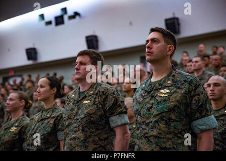 Les marines, les marins et leurs familles au garde à vous pendant l'Ancre par le III Marine Expeditionary Force Band au cours d'une cérémonie de transfert de commandement le 29 juin 2018 au Camp de favoriser, l'Okinawa au Japon. Le brig. Le général Keith D. Reventlow a assumé le commandement du 3e Groupe logistique maritime durant la cérémonie. Reventlow est originaire de Newtown, dans le Connecticut. (U.S. Marine Corps photo de la FPC. Terry Wong) Banque D'Images