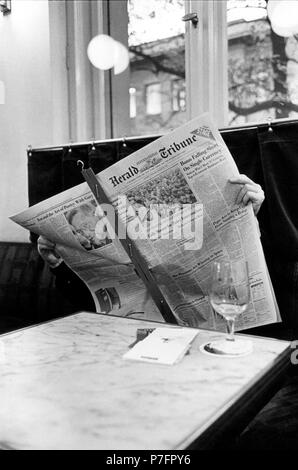 L'homme lit l'Herald Tribune journal dans un café, 1950, ca. 1959, lieu exact inconnu, Allemagne Banque D'Images