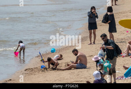 Bournemouth, Royaume-Uni. 6e juillet 2018. Les personnes qui utilisent leurs téléphones portables sur la plage de Bournemouth au cours de la vague de chaleur du mois de juillet. Crédit : Thomas Faull / Alamy Live News Banque D'Images