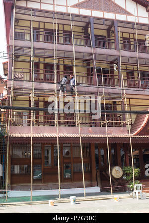 Les travailleurs qui travaillent sur des échafaudages en bambou Vientiane, Laos, Asie. Banque D'Images