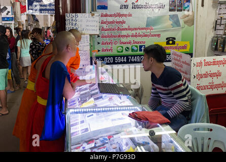 Des moines bouddhistes à boutique de téléphonie mobile dans le centre commercial Talat Sao, Vientiane, Laos, Asie. Banque D'Images