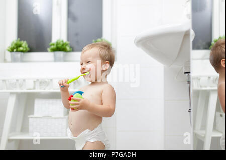 Adorable enfant apprentissage comment se brosser les dents dans la salle de bains Banque D'Images