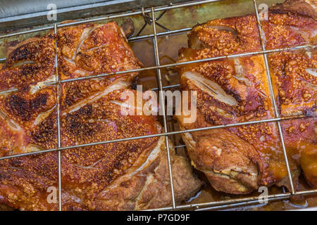 Flan de porc étant grillés dans une fosse Banque D'Images