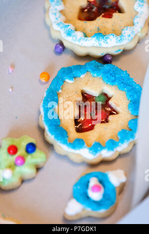 Le bac papier de cadeau fort remplis de beaucoup de givrage décoré avec des bonbons colorés sucre émaillés bleu artificiel de vacances de Noël fait maison de boulangerie sprinkles cooki Banque D'Images