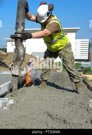 Naples, Italie (13 septembre 2016) - 3e classe constructeur Elizabeth Morton, affecté à la base navale américaine de Naples Département des travaux publics, se déverse dans une trame de béton qui formeront la dalle pour un chenil sur NSA Naples. Les services des Travaux publics marine soutenir et maintenir des installations et l'infrastructure sur les installations dans le monde entier dans le cadre de la Naval Facilities Engineering Command (NAVFAC) mission générale. Banque D'Images