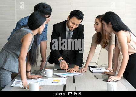 Smart manager expliquant réunion interne à son équipe de projet dans un bureau moderne. Le groupe ethnique de personne d'affaires en litige. Projet et Business c Banque D'Images