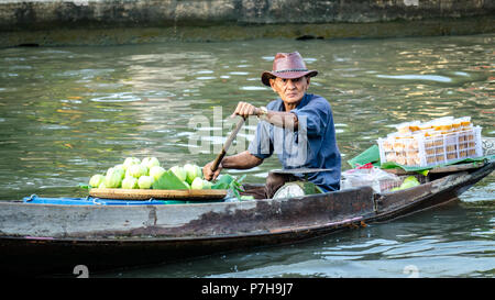 Un vendeur de l'aviron de canaux sur la rivière Mae Klong entre les maisons le matin et la vente des aliments sur un bateau en bois, Amphawa, Thaïlande Banque D'Images