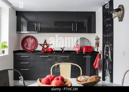 Télévision la façade gris foncé en unités de cuisine cuisine moderne avec vintage tolix metal chaise de salle à manger Banque D'Images