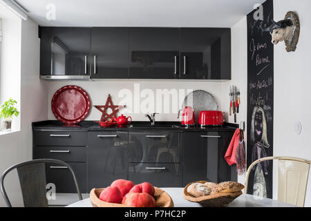 Télévision la façade gris foncé en unités de cuisine cuisine moderne avec vintage tolix metal chaise de salle à manger Banque D'Images