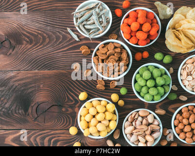 Assortiment de différents snack pour la bière, vin, partie. D'arachides dans la glaçure de coco, vert, rouge piment vasabi épicé, fromage jaune glaze, chips, pistaches, Banque D'Images