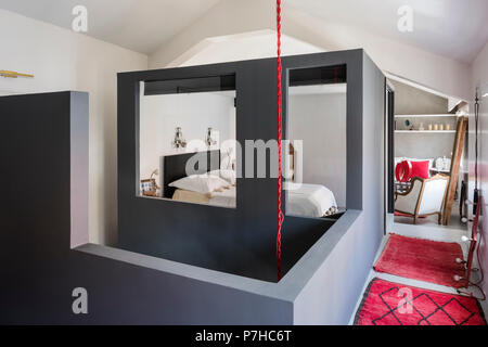 Encadré en Chambre dans appartement moderne de type loft avec tapis marocain rouge Banque D'Images