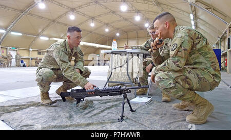 38e Brigade de soutien Le Sgt. Zachary Green explique la mitrailleuse M249 à un classificateur au cours de l'armée américaine meilleur guerrier centrale concours tenu au Camp Arifjan, au Koweït, le 28 juin. Green a remporté le concours de meilleur guerrier. Banque D'Images