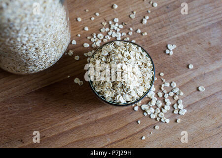 Pour l'avoine naturelle organique dans le porridge en tas sur la table en bois Bol en céramique Banque D'Images