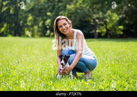 Belle femme aime passer du temps dans la nature avec son joli chien Jack Russell Terrier. Banque D'Images