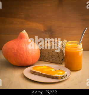 Confiture de citrouille dans un pot avec du pain frais et du beurre Banque D'Images