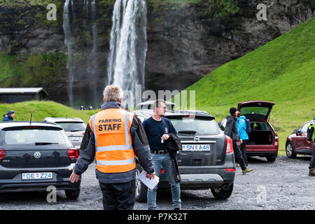 Seljalandsfoss, Islande - 14 juin 2018 : : parking lot par cascade avec un garde général écrit des billets en orange sont acquises, les touristes, les voitures à pied Banque D'Images