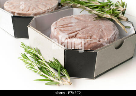 Pile de matières premières fraîches burger patty isolé sur blanc avec Rosemary Banque D'Images