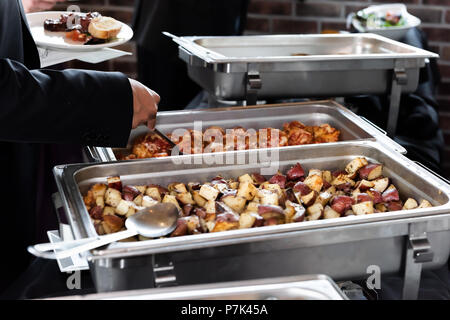 Bac buffet chaud, des pommes de terre, poulet à l'aide de cuillère pour servir de la nourriture à la plaque en banquet, mariage, ou d'un restaurant à l'intérieur Banque D'Images