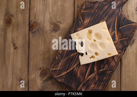 Fromage hollandais traditionnel avec des trous, sur une planche en bois vintage, fond de bois. Les produits laitiers. Copier l'espace. Au-dessus Banque D'Images