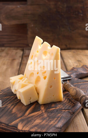 Fromage hollandais traditionnel avec des trous, sur une planche en bois vintage, fond de bois. Les produits laitiers. Copy space Banque D'Images