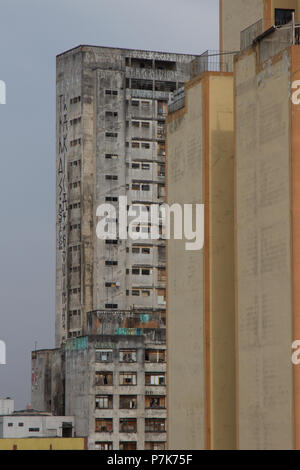 Condamné abandonné énormes bâtiments utilisés comme logements sociaux bidonville par le mouvement sur l'arrière-plan d'un ancien bâtiment résidentiel jaune. San Paolo. Le Brésil. Banque D'Images