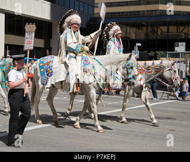 Le chef de Stoney Nakoda en robe traditionnelle se déplace à cheval dans le Stampede de Calgary. Le défilé dans le centre-ville déclenche le Stampede de Calgary chaque année. Alberta, Canada. Rosanne Tackaberry/Alamy Live News Banque D'Images