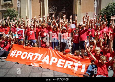 TURIN, ITALIE 7 Juillet 2018 : flash mob "UN T-shirt rouge pour arrêter le saignement de l'humanité". Flash mob qui a eu lieu au même moment dans toute l'Italie pour manifester en faveur des migrants, en particulier les enfants. Le rouge est la couleur de la shirts d'enfants qui meurent en mer pour rejoindre l'Europe. De rouge étaient habillés les trois enfants se sont noyés et dont les corps sans vie ont été retrouvés le 29 juin dernier en face de la côtes libyennes. De rouge sera plus habillé par les mères, dans l'espoir que, dans le cas de naufrage, cette couleur me rappelle l'attention des sauveteurs.Crédit : Michele D'Ottavio/Alamy Live News Banque D'Images