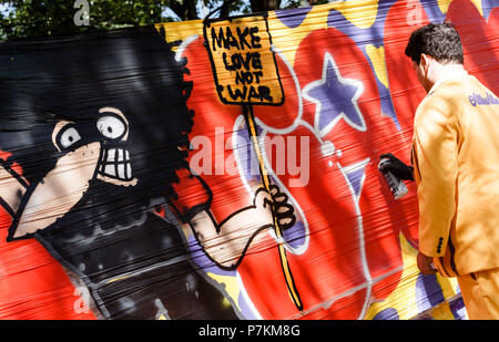 Hambourg, Allemagne. 07Th Juillet, 2018. Un graffiti artiste de pulvériser une bannière qui se lit "Make Love Not War avant le début d'une manifestation. Un an après le G20 des émeutes, les manifestants à Hambourg retournent à la rue. Photo : Markus Scholz/dpa/Alamy Live News Banque D'Images